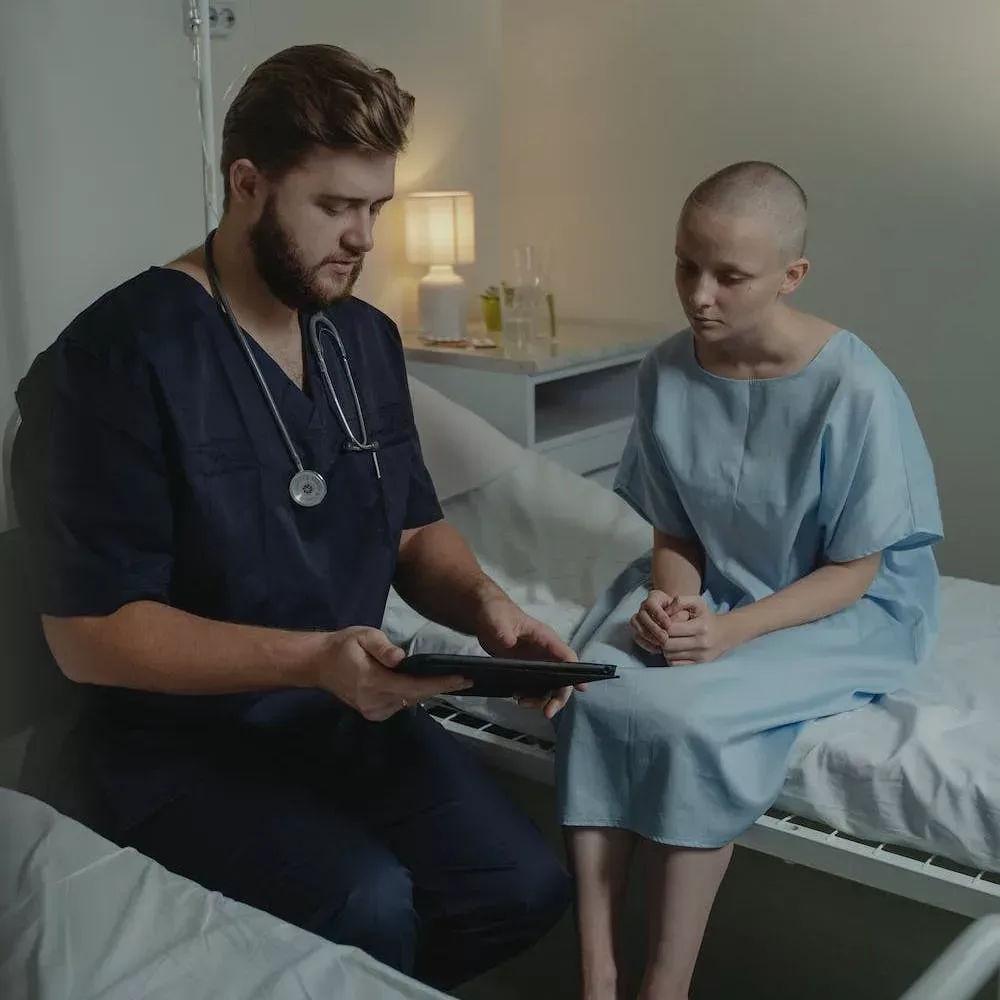 nurse showing tablet chart to bedside patient
