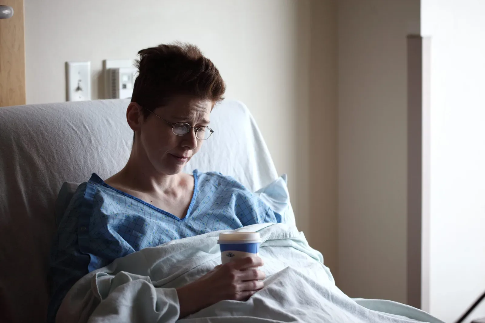 patient in bed with cup of coffee