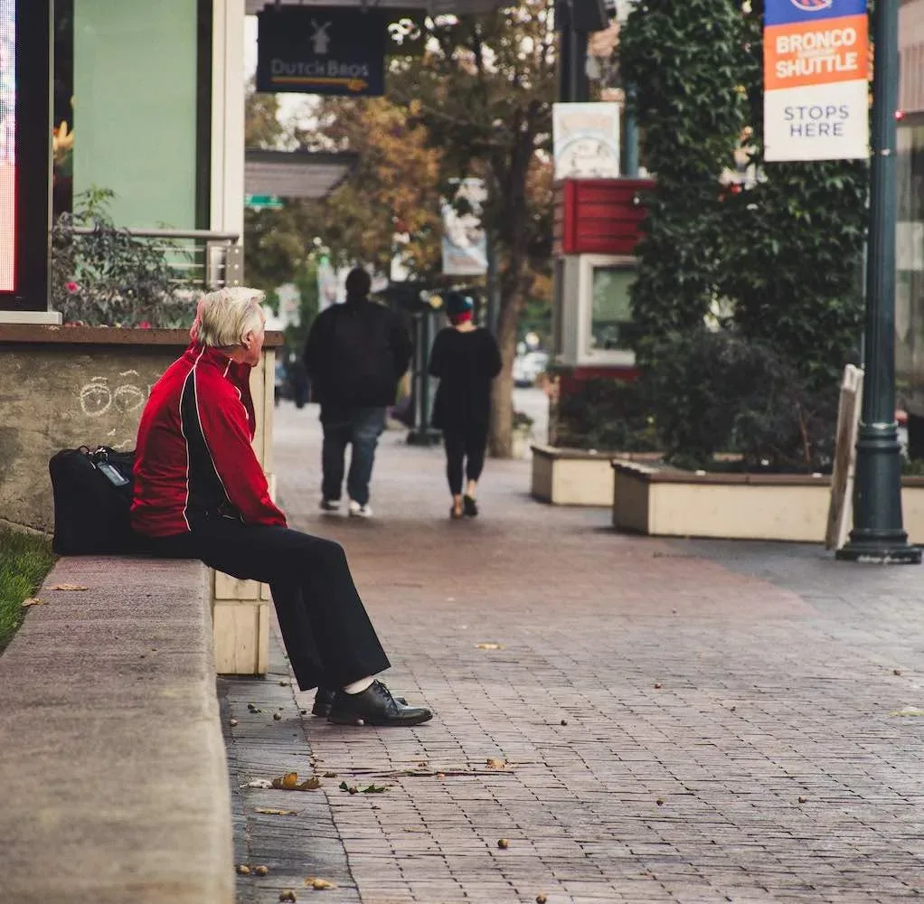 lonely man sitting in the street